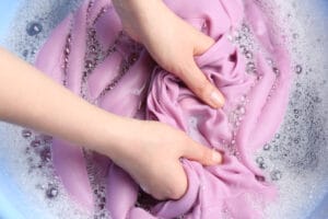 Top,View,Of,Woman,Hand,Washing,Color,Clothing,In,Suds,